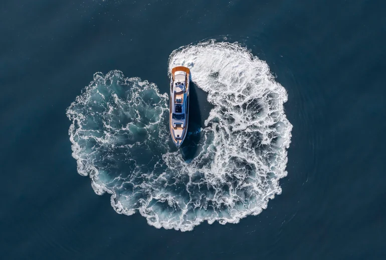 Sailing yacht heeled with crew at the helm