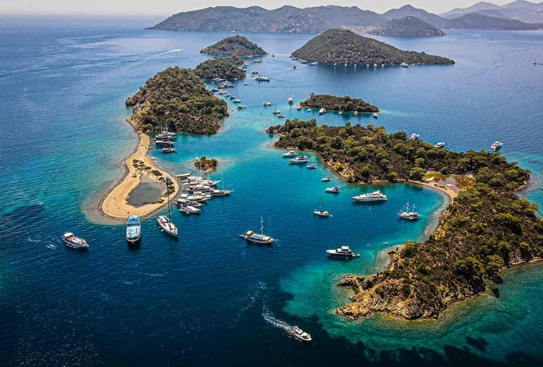 Yacht at anchor in a Turkish bay surrounded by pine forest