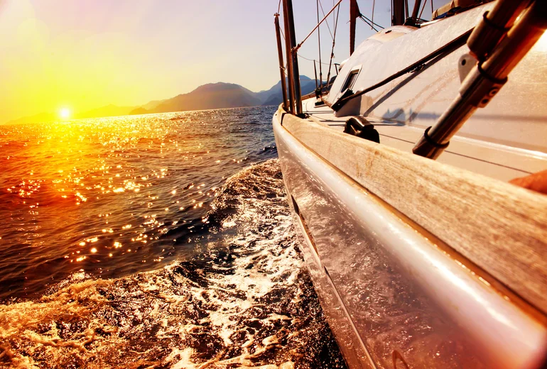 Yacht crew dining on aft deck at sunset